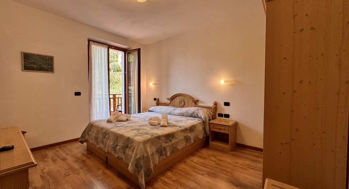 Camera doppia con balcone | Uno spazio luminoso e versatile, ideale per soggiorni di coppia o per chi desidera il comfort di ambienti accoglienti e ben organizzati.