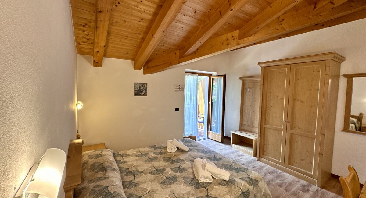 Camera doppia con balcone | Uno spazio luminoso e versatile, ideale per soggiorni di coppia o per chi desidera il comfort di ambienti accoglienti e ben organizzati.