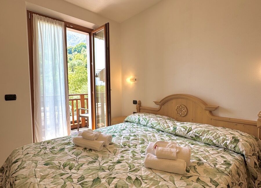 Camera doppia con balcone | Uno spazio luminoso e versatile, ideale per soggiorni di coppia o per chi desidera il comfort di ambienti accoglienti e ben organizzati.