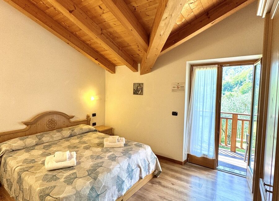 Camera doppia con balcone | Uno spazio luminoso e versatile, ideale per soggiorni di coppia o per chi desidera il comfort di ambienti accoglienti e ben organizzati.